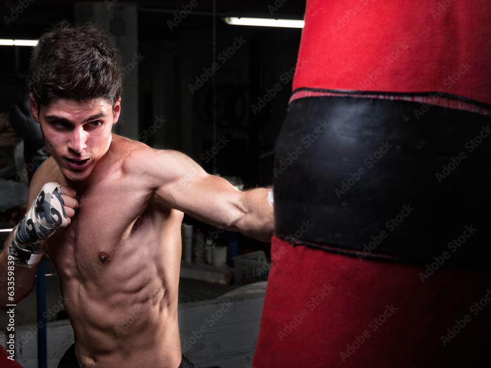 Young caucasian Boxer training with a punching bag