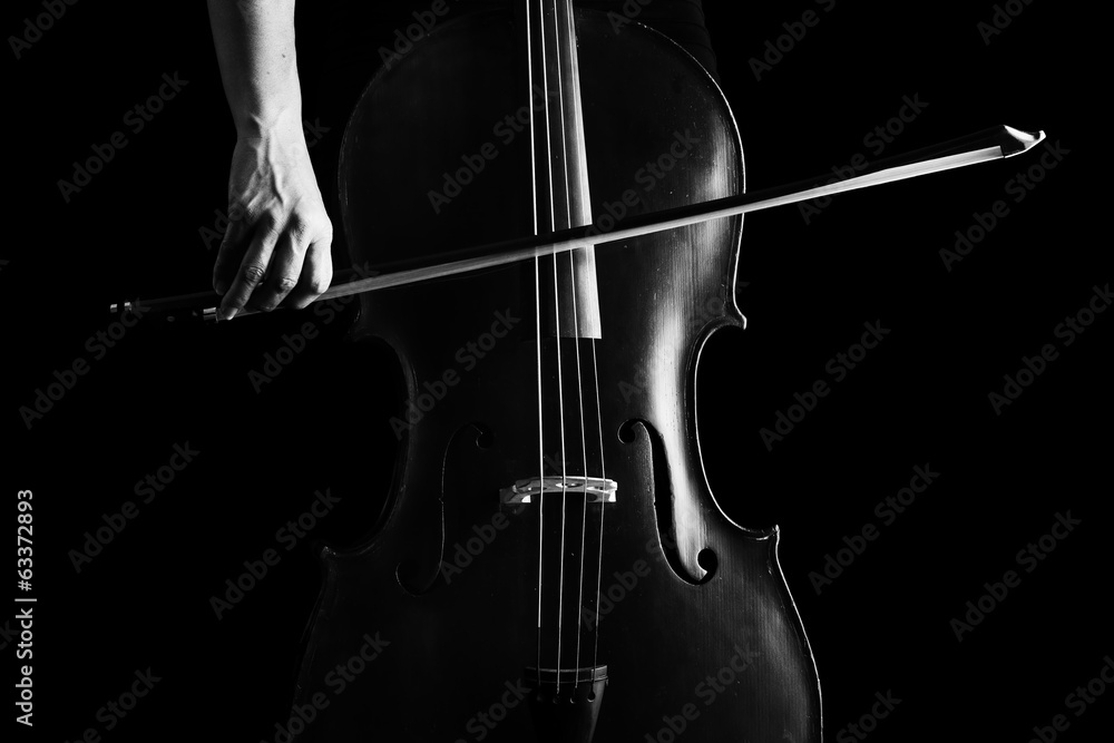 Plakat Piękna brunetka gra na wiolonczeli z selektywnym światłem w kolorze czarnym d
