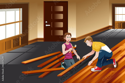 Young couple installing hardwood floor