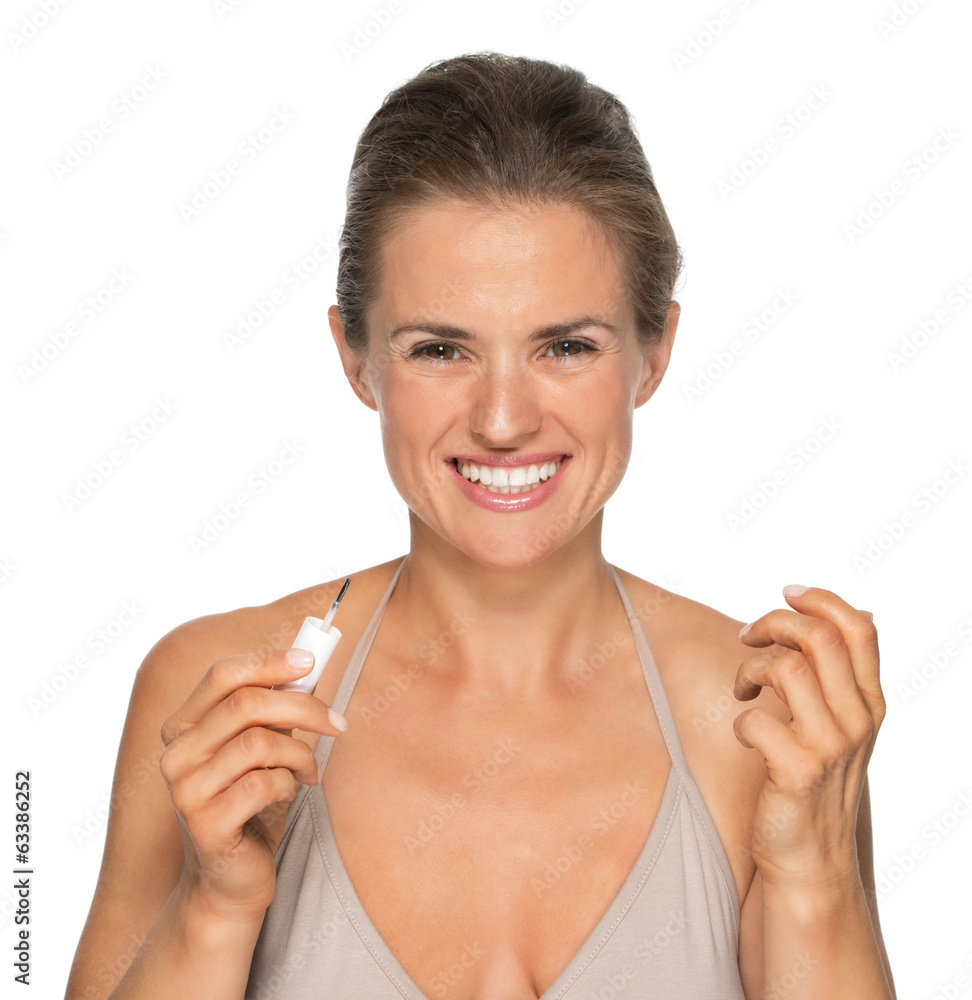 Portrait of smiling young woman applying nail polish Portrait of smiling young woman applying nail polish