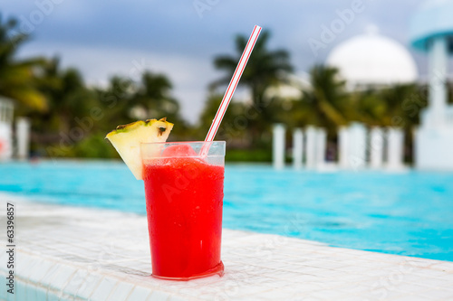 Glass of Strawberry Daiquiri cocktail next to a swimming pool