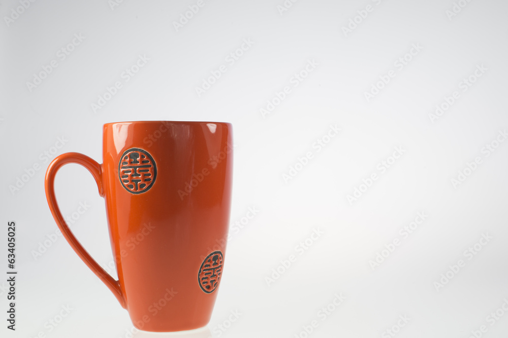 tazza arancio/rosso su sfondo bianco