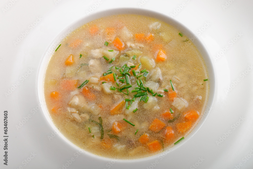 Bone Broth in Small Soup Bowl Served with Fresh Herbs, Garlic