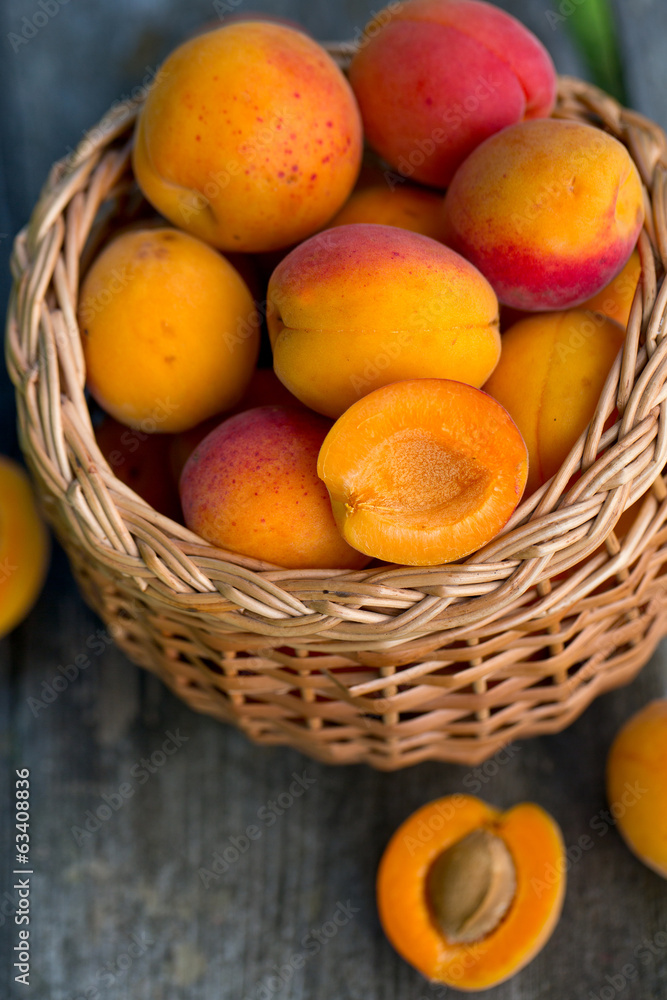 apricots in a basket on wooden background apricots in a basket on wooden background