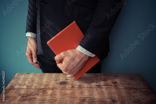 Man with book at desk photo