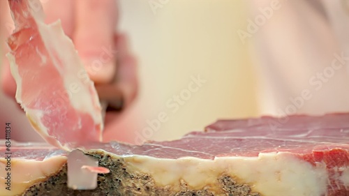 hands cutting slice dried ham