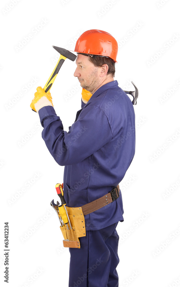 Worker in hard hat holding hammers Worker in hard hat holding hammers