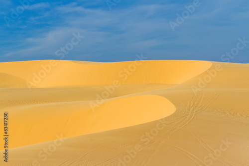 Sand dunes against blue sky 