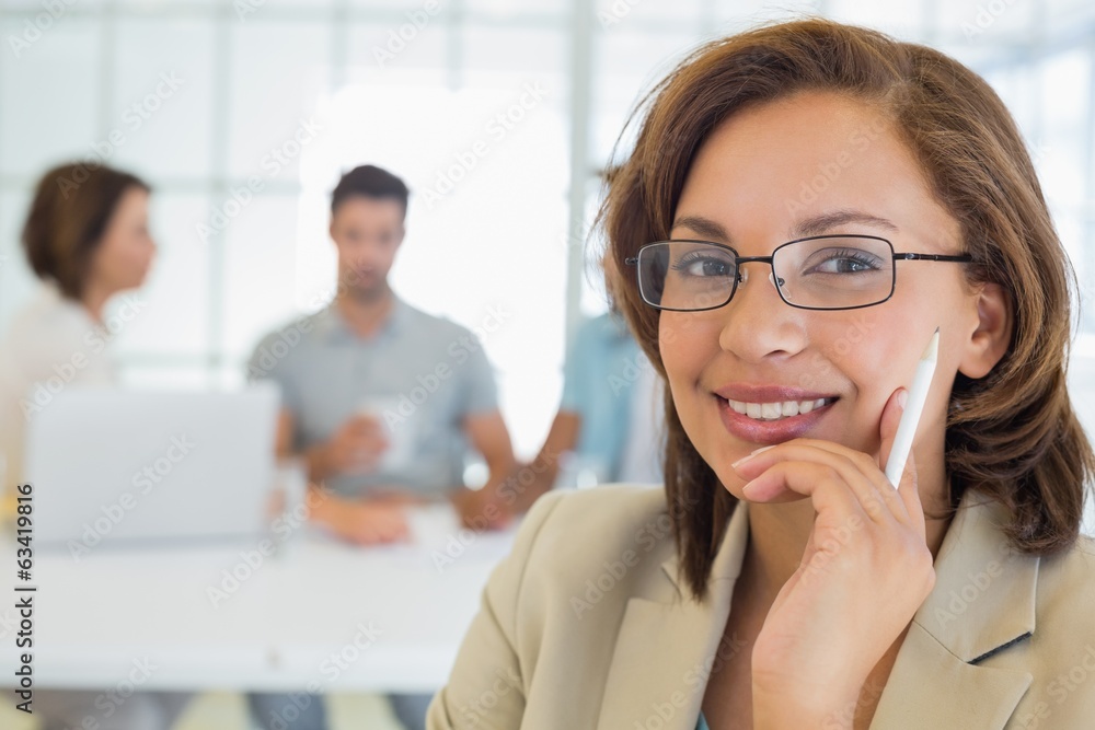 Obraz premium Smiling businesswoman with colleagues in meeting