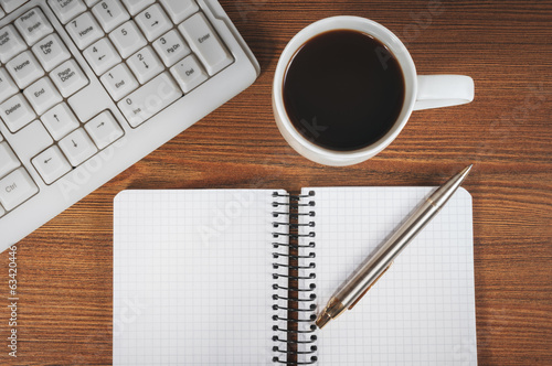 Blank notepad, keyboard, pen and coffee cup