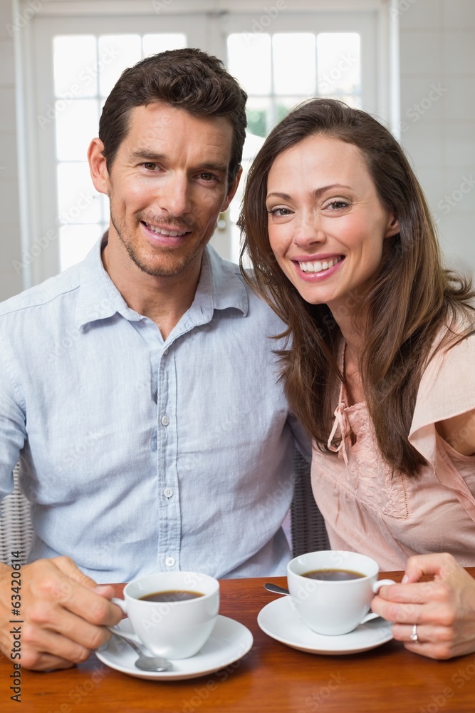 Happy couple with coffee cups at home Happy couple with coffee cups at home