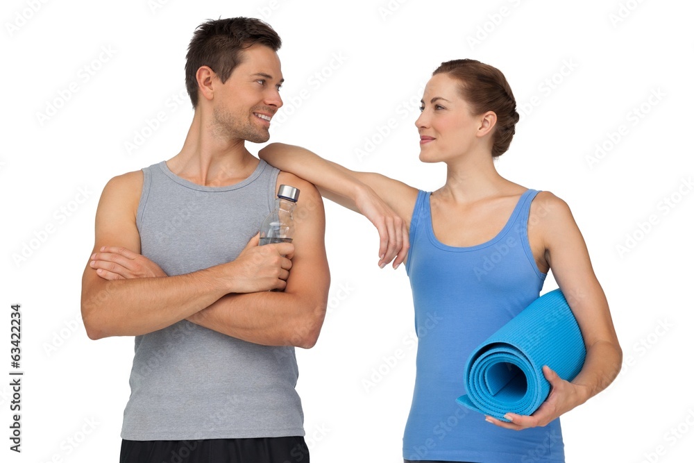 Fit young couple with exercise mat and water bottle Fit young couple with exercise mat and water bottle