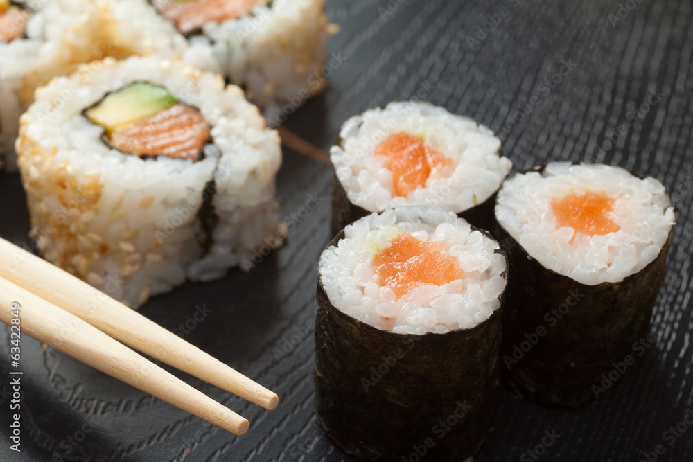 sushi rolls on black plate and chopsticks sushi rolls on black plate and chopsticks