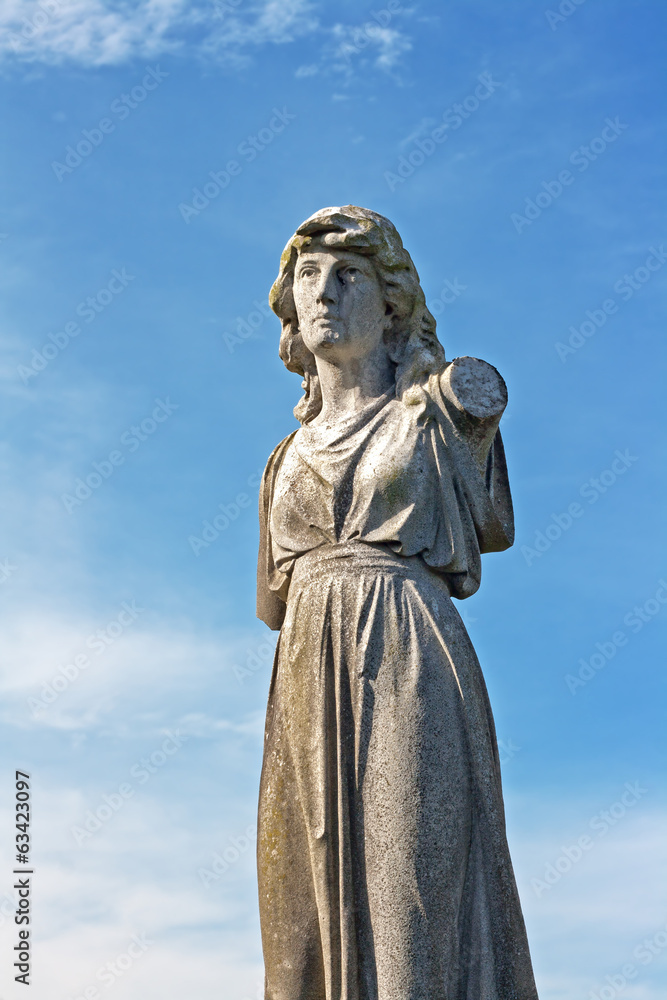 Female weathered statue in ancient graveyard