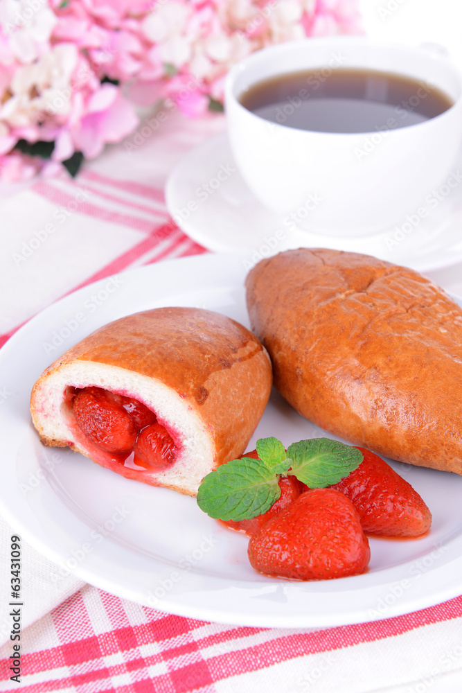 Fresh baked pasties with strawberries on plate on table Fresh baked pasties with strawberries on plate on table