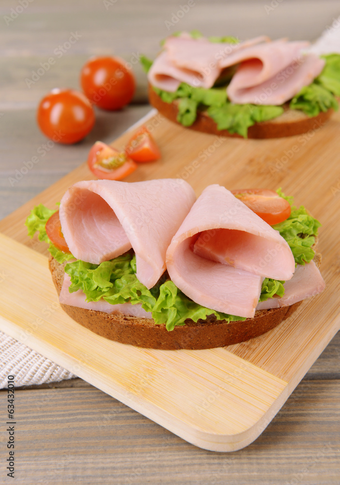 Delicious sandwiches with lettuce and ham on table close-up Delicious sandwiches with lettuce and ham on table close-up
