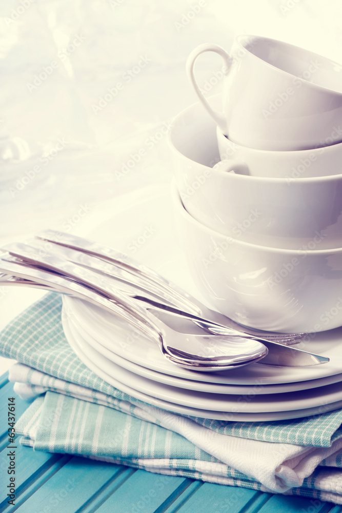 Fototapeta premium White plates and cups on blue napkins
