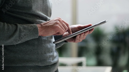 Man touching screen and browsing on tablet, closeup