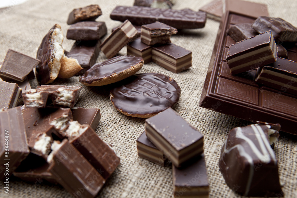 Broken chocolate bar and spices on wooden table Broken chocolate bar and spices on wooden table