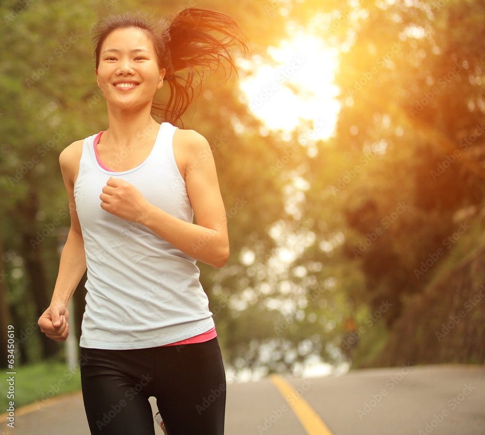 Fototapeta premium healthy lifestyle fitness woman running sunrise forest road