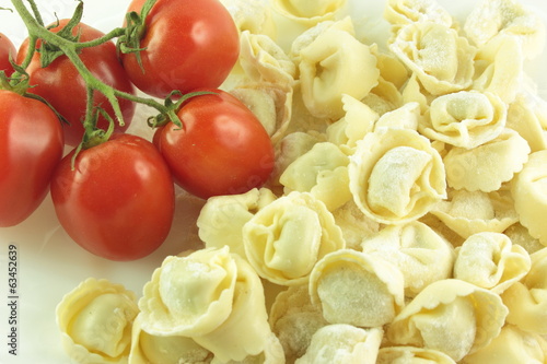 Tortellini crudi con un grappolo di pomodori rossi