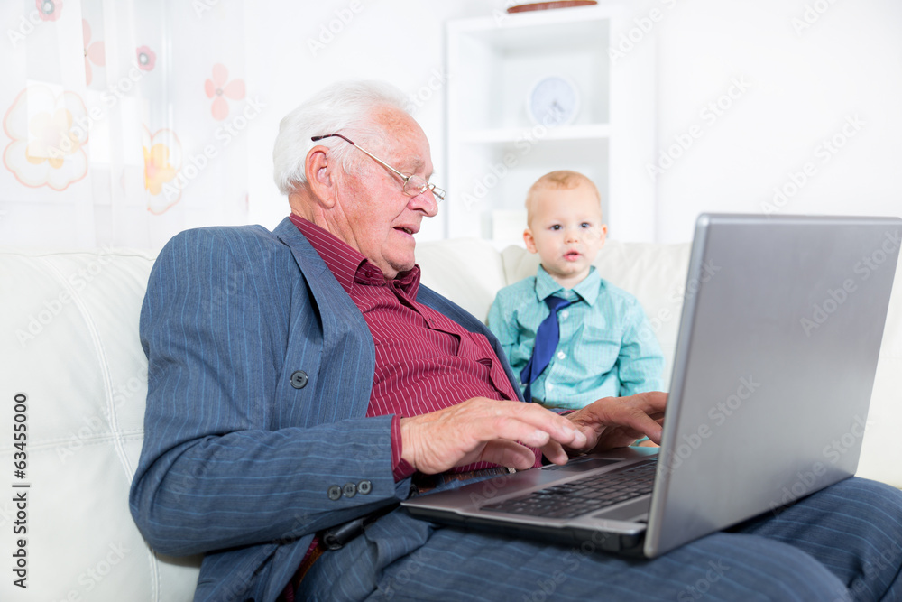 Grandfather and his grandson with laptop Grandfather and his grandson with laptop