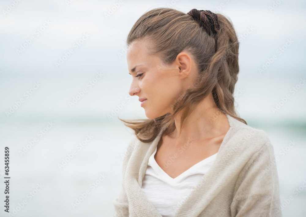 Portrait of relaxed young woman on cold beach