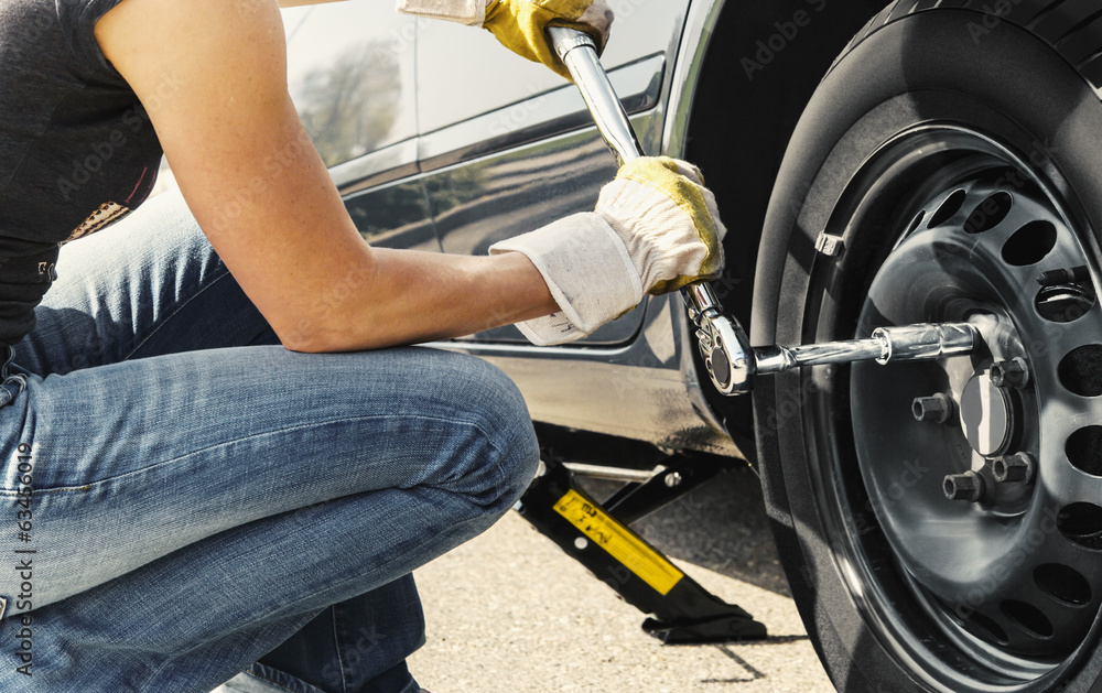 Woman changing tire car Woman changing tire car