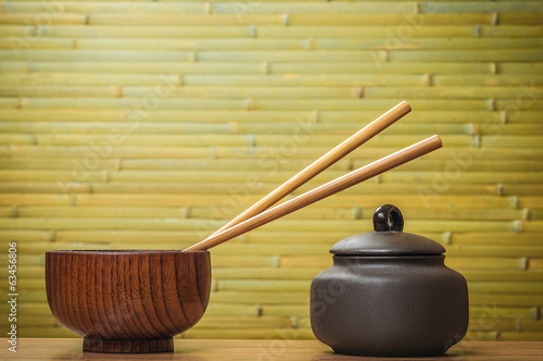 Chopsticks and bowls on bamboo background