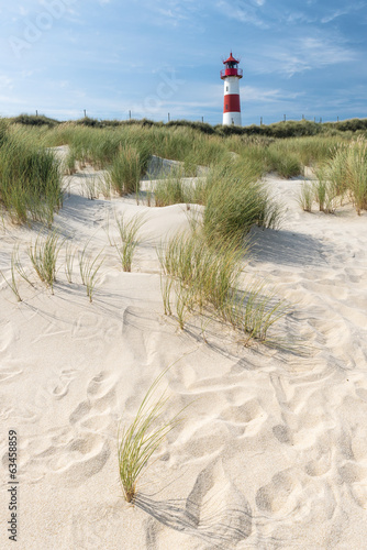 Red - white lightouse on wide sand dune on amazing German island Sylt.