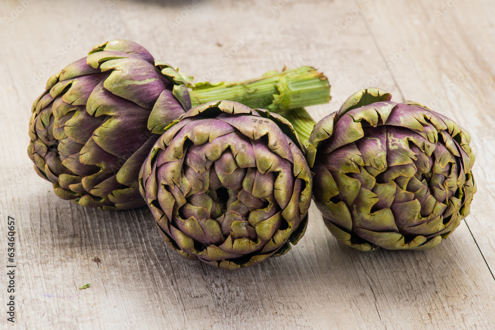Carciofi freschi appoggiati su un tavolo Carciofi freschi appoggiati su un tavolo