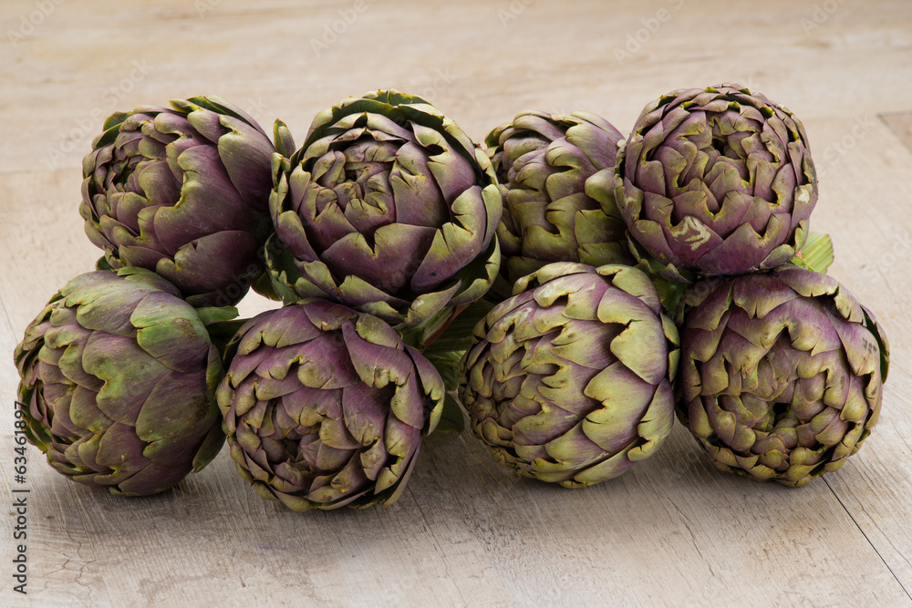 Carciofi freschi appoggiati su un tavolo Carciofi freschi appoggiati su un tavolo