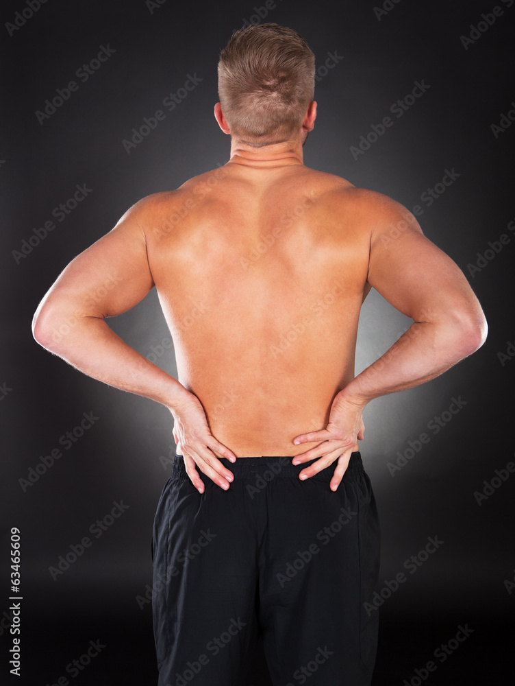 Strong muscular man with backache Strong muscular man with backache
