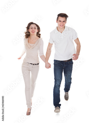 Couple In Casuals Walking Over White Background © Andrey Popov