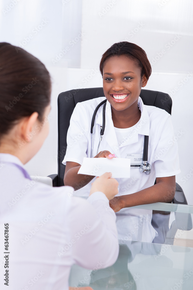 Happy female dentist giving prescription to patient Happy female dentist giving prescription to patient