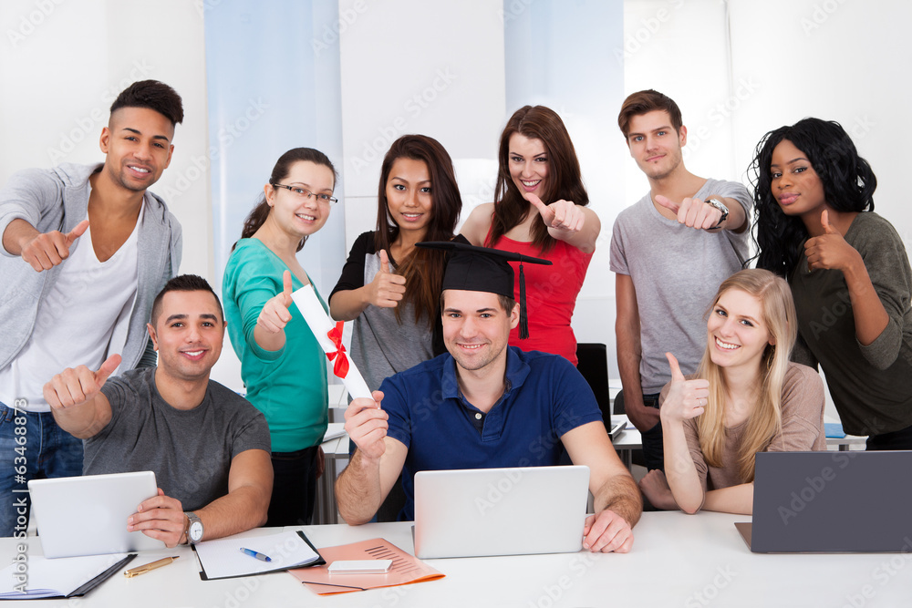 Student Holding Degree With Classmates Gesturing Thumbs Up Student Holding Degree With Classmates Gesturing Thumbs Up