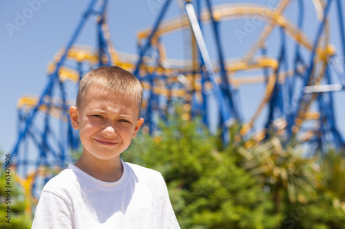 Boy next to a roller coaster