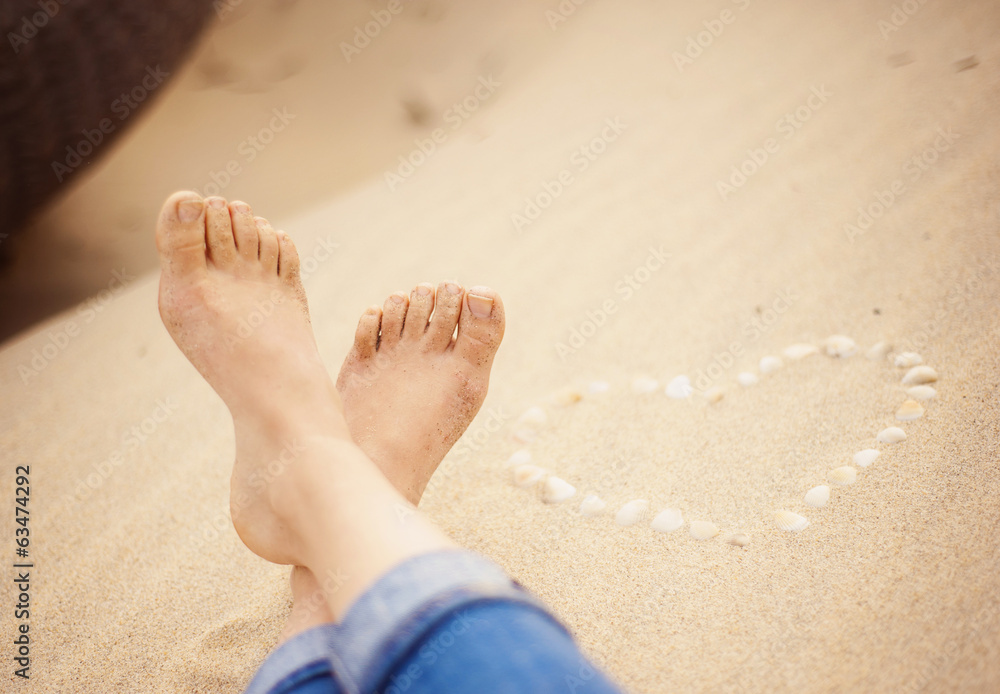 Closeup of female feet at the beach - obrazy, fototapety, plakaty 