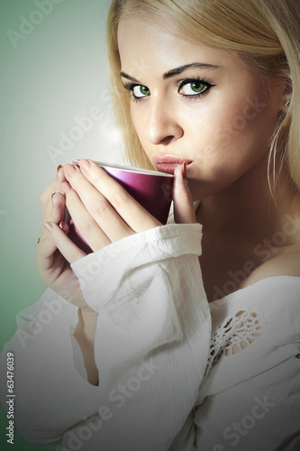 Beautiful blond woman drinking a Tea. Vapor Cup of Coffee. Hot