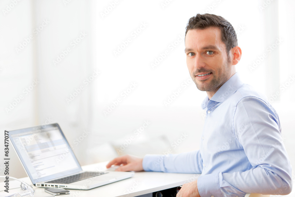 Young business man working at home on his laptop Young business man working at home on his laptop