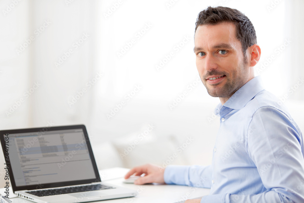 Young business man working at home on his laptop Young business man working at home on his laptop