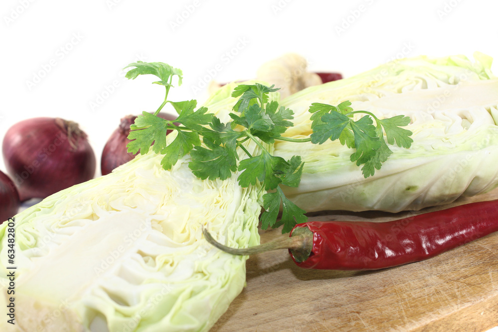 Spitzkohl mit Peperoni auf einem Brett Spitzkohl mit Peperoni auf einem Brett