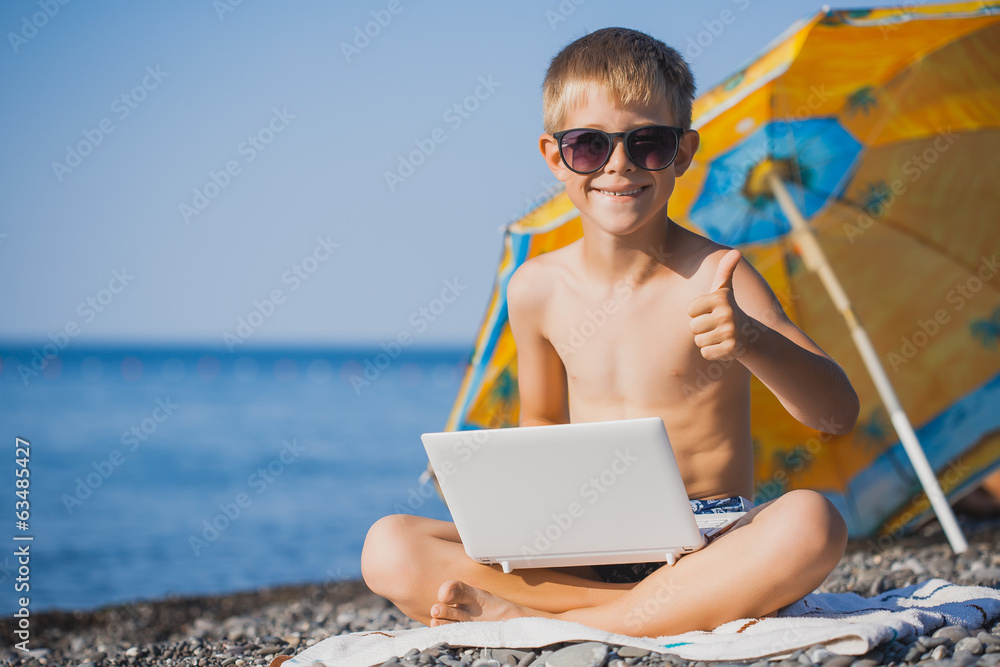 happy smiling boy is sunbathing on a beach