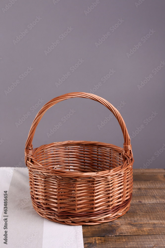 Empty wicker basket on wooden table, on dark background Empty wicker basket on wooden table, on dark background