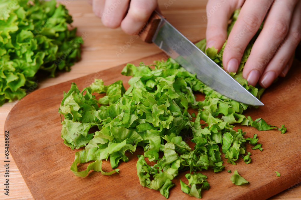 Chopped green lettuce on wooden board close-up Chopped green lettuce on wooden board close-up