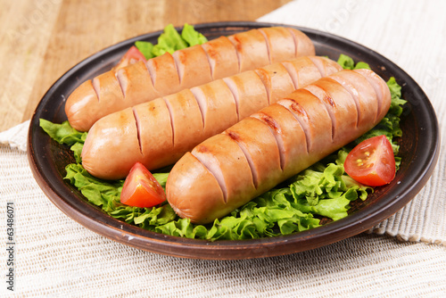 Grilled sausage on plate on table close-up