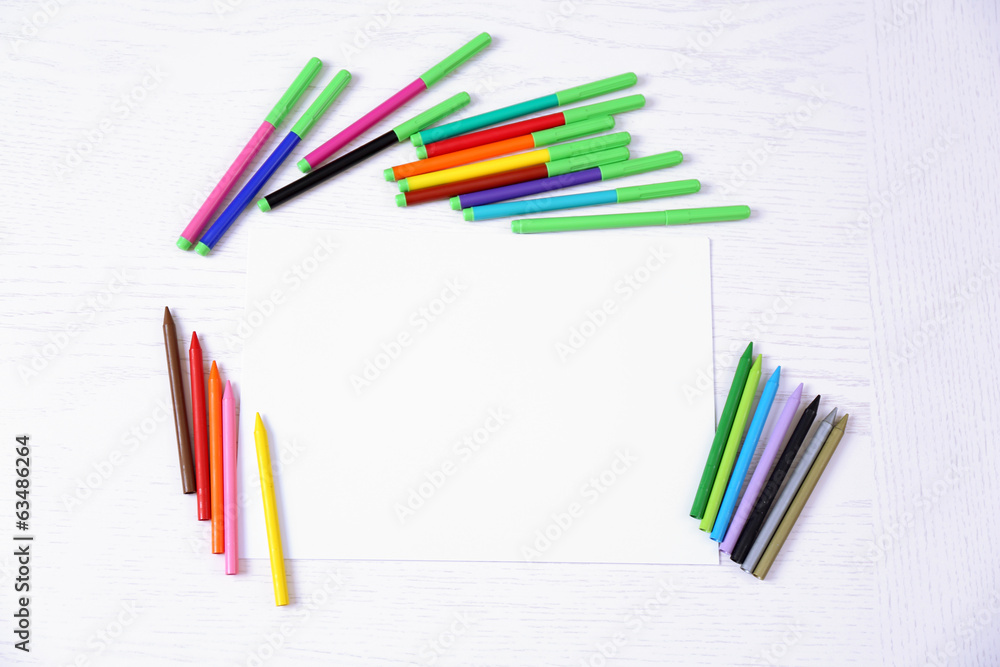 Fototapeta premium Colored pencils and blank paper sheet on wooden table