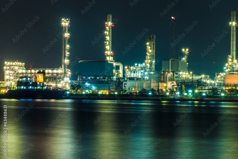 Oil refinery at night with shadow in river