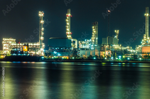 Oil refinery at night with shadow in river