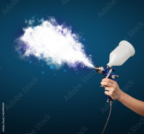 Painter with airbrush gun and white magical smoke